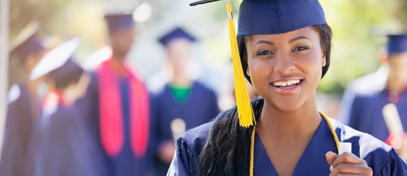 Close up of a graduating student wearing a graduation cap and gown