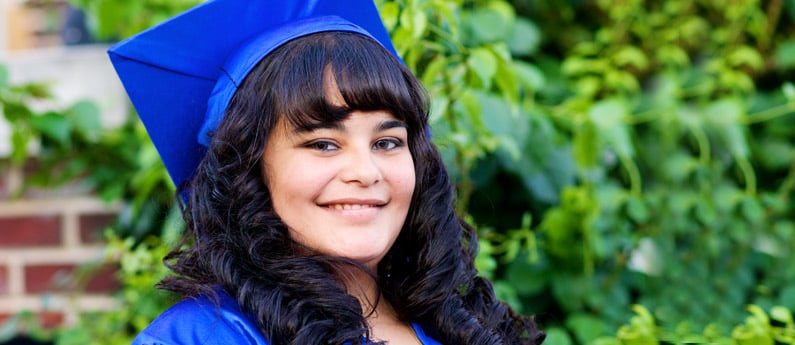 Close up of a graduating student in a graduation cap and gown.