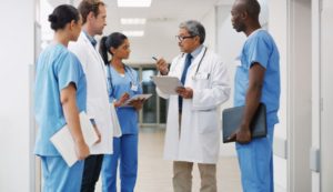 Doctors and Medical Assistants Speak In Hallway