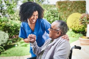 A nurse talks with a patient in a wheelchair
