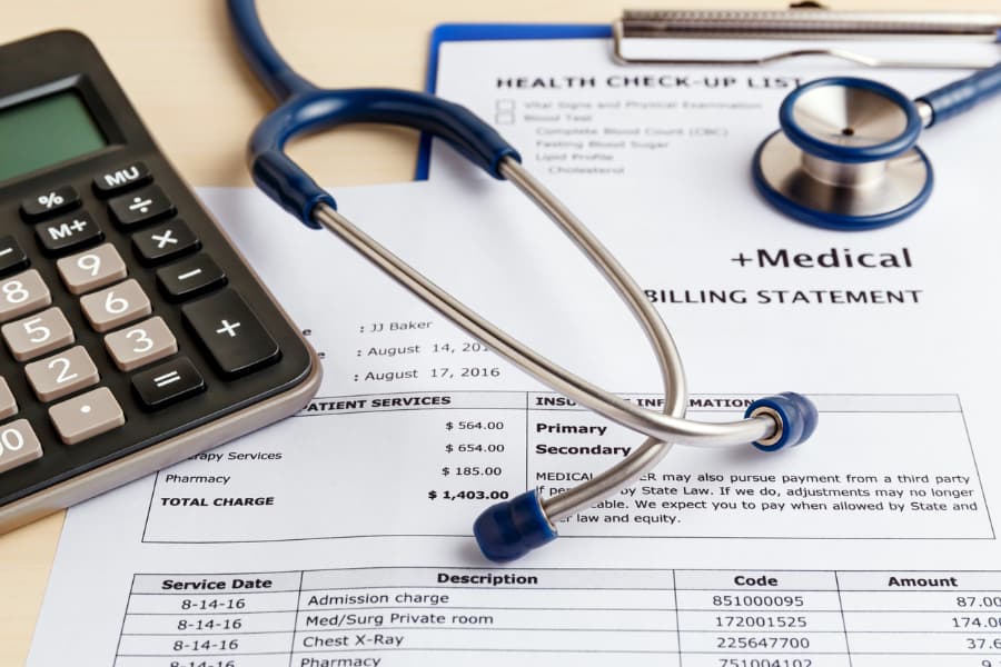 Medical coding form with a calculator to determine healthcare costs, and a stethoscope